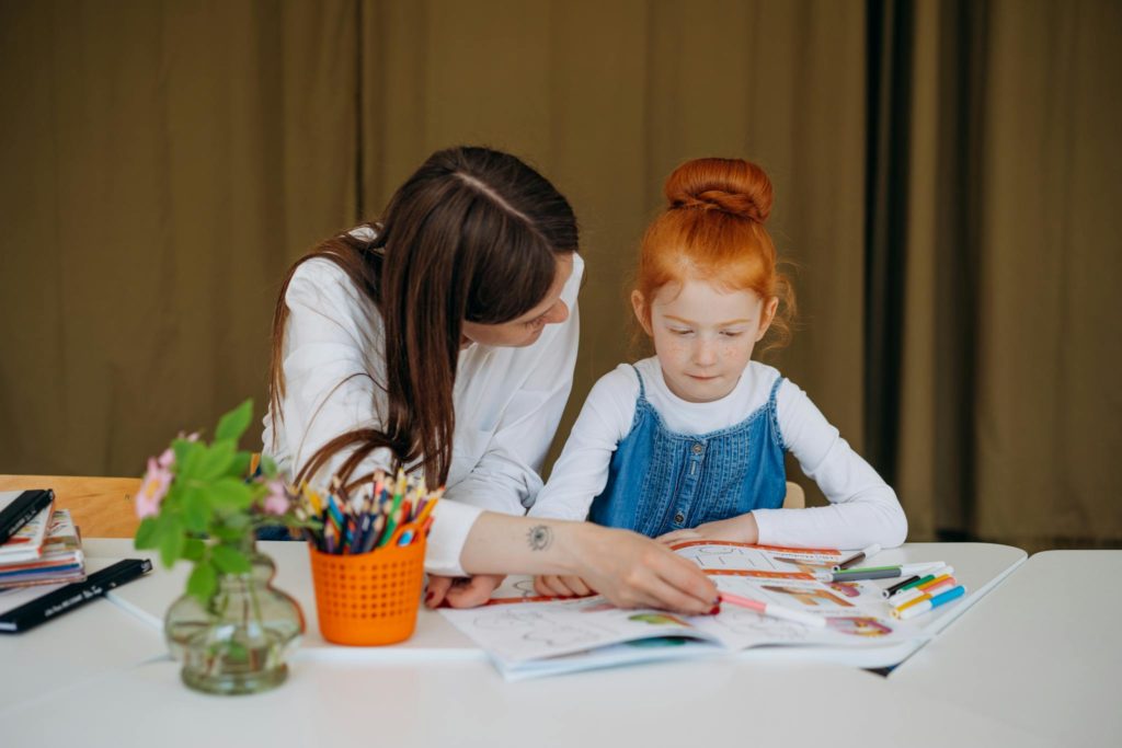 A Woman Teaching a Girl Student