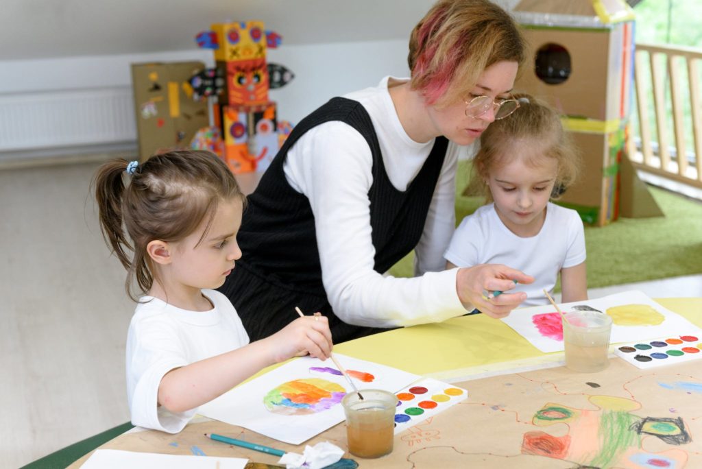 A Woman Teaching Arts to Preschoolers