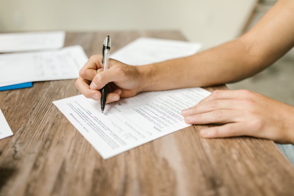 Close-Up Shot of a Person Filling Out a Form