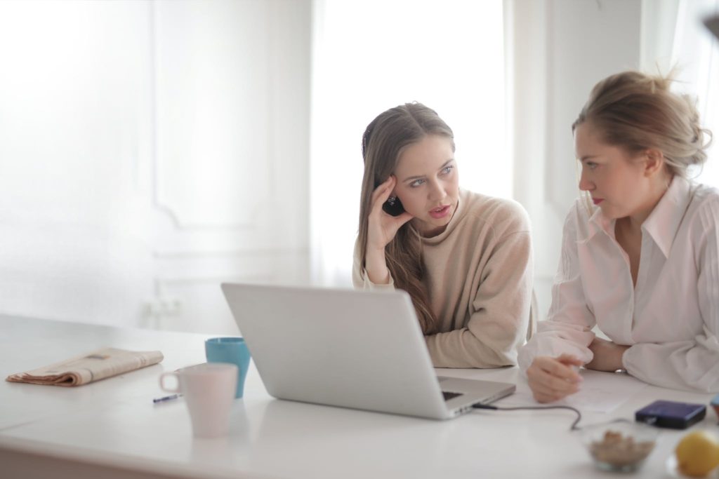 Thoughtful coworking women discussing project in home office