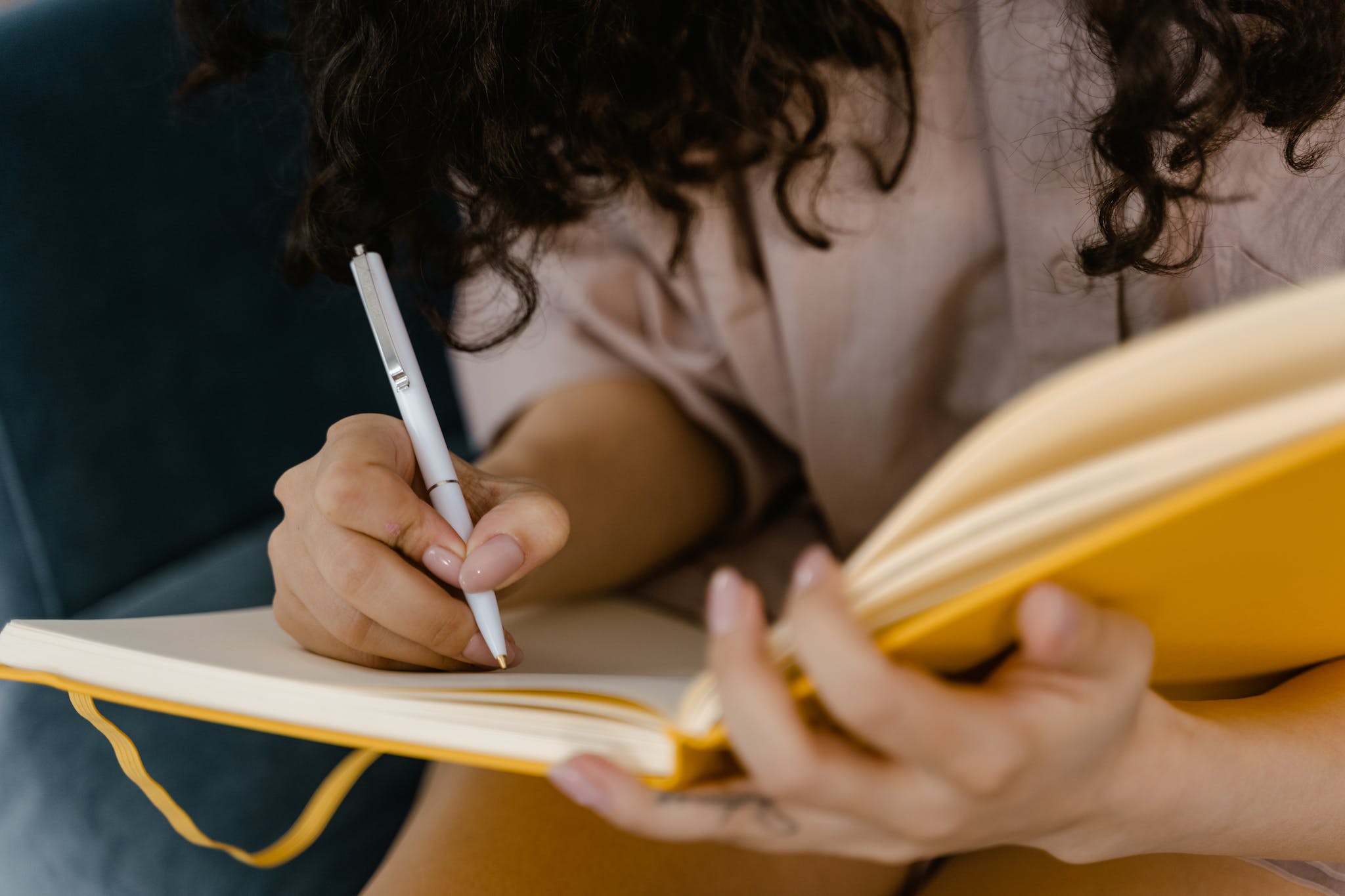 Woman in White Shirt Writing on White Paper